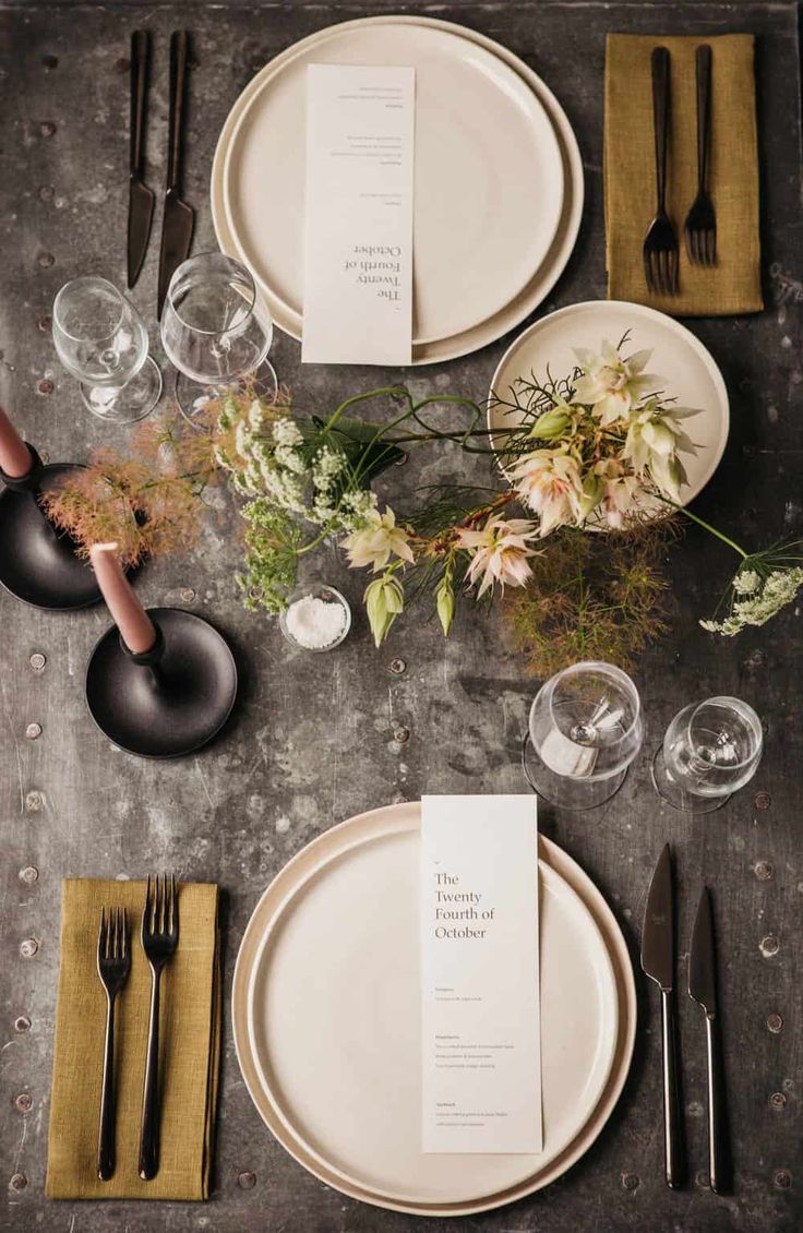 the table is set with plates, silverware and place settings for an elegant dinner