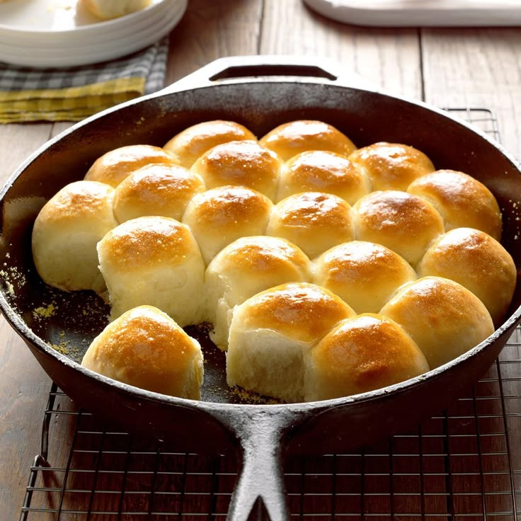 a pan filled with bread rolls on top of a wooden table