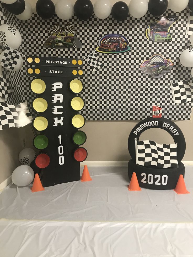 a table topped with traffic lights and balloons in the shape of race signs on top of each other