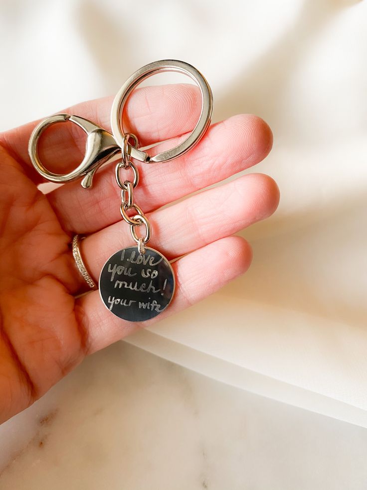 someone is holding their keychain with writing on it