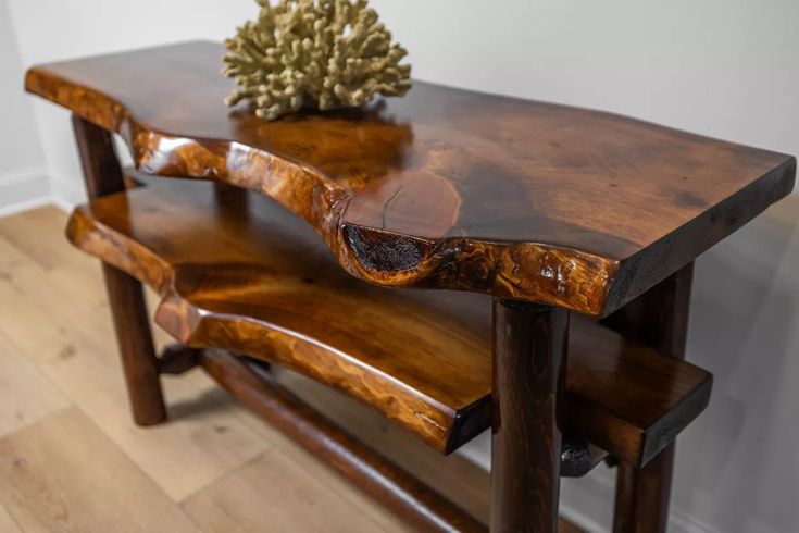 a wooden table sitting on top of a hard wood floor next to a white wall