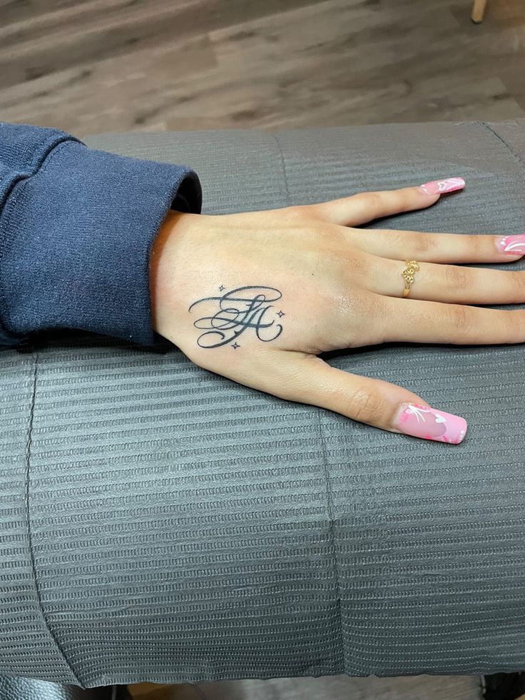 calligraphy hand tattoo Hand Tattoo Name For Women, Letter Initial Tattoo Placement, Hand Tattoo Baddie, Where To Put Name Tattoos, Thumb Tattoos Side Words, K Hand Tattoo, La Hand Tattoo, Initial Tattoo Hand, Hand Initial Tattoo