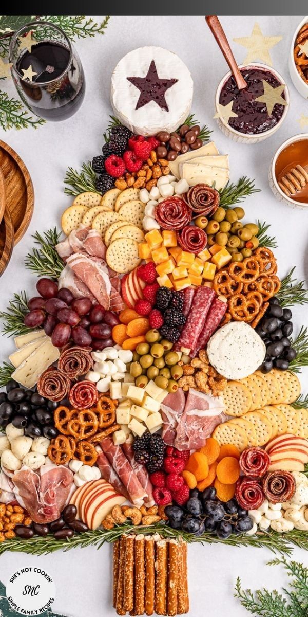 a christmas tree made out of cheeses, crackers and meats on a table