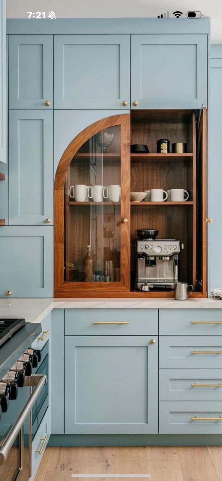 a kitchen with blue cabinets and white counter tops is pictured in this image, there is a coffee maker on the cabinet