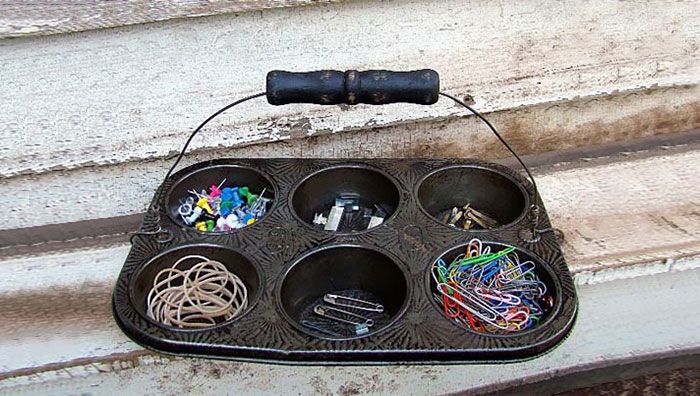 an old metal tray with many different items in it sitting on the side of a building