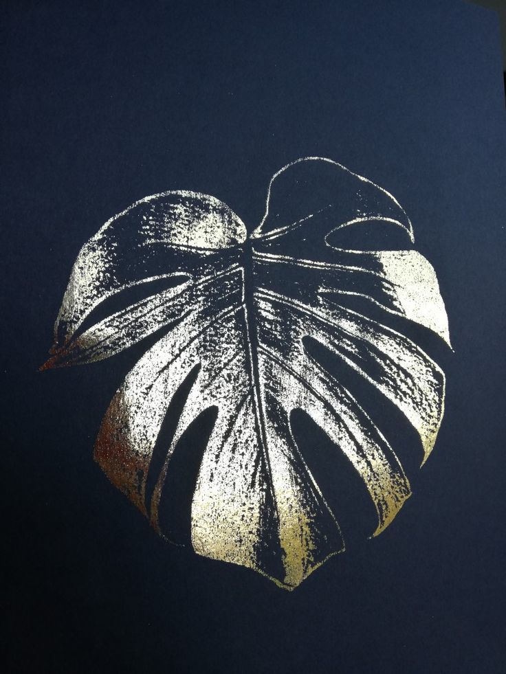 a close up of a leaf on a black background with gold foiling in the shape of a monster's tail