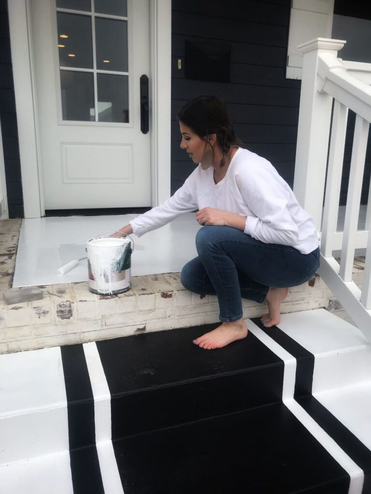 a woman is painting the steps outside her house