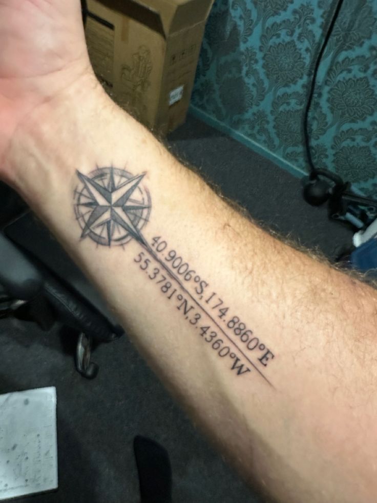 a man with a compass tattoo on his arm