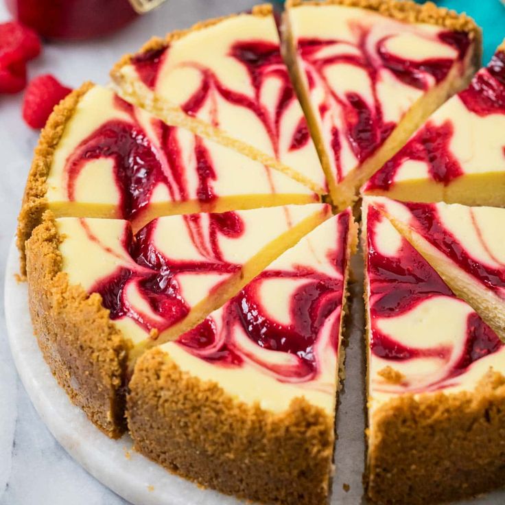 a cheesecake topped with raspberry sauce and sliced into slices