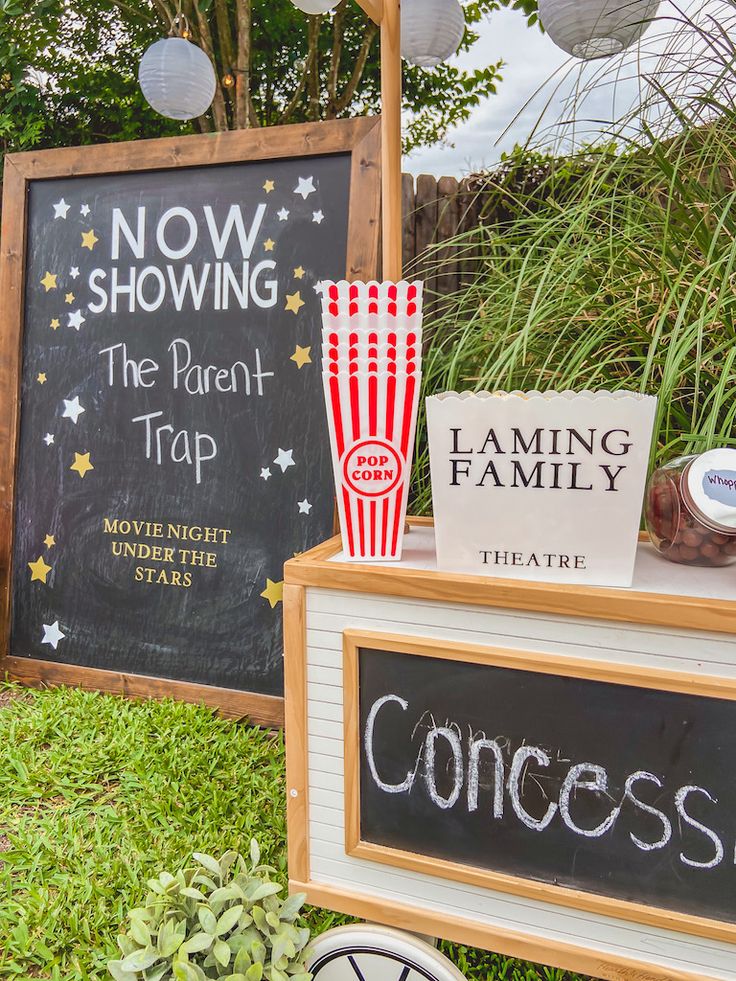 an outdoor movie themed party with popcorn and chalkboard signs