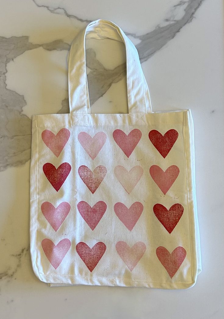 a bag with hearts painted on it sitting on a marble countertop next to a wall