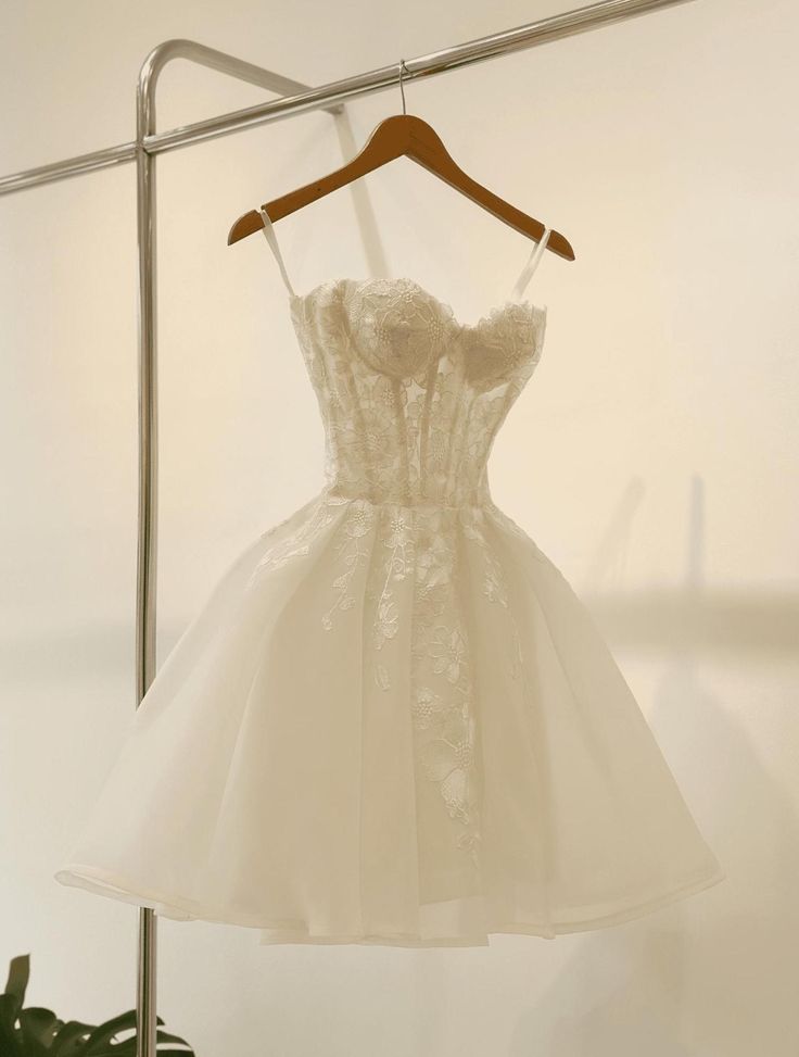 a white dress hanging on a clothes rack