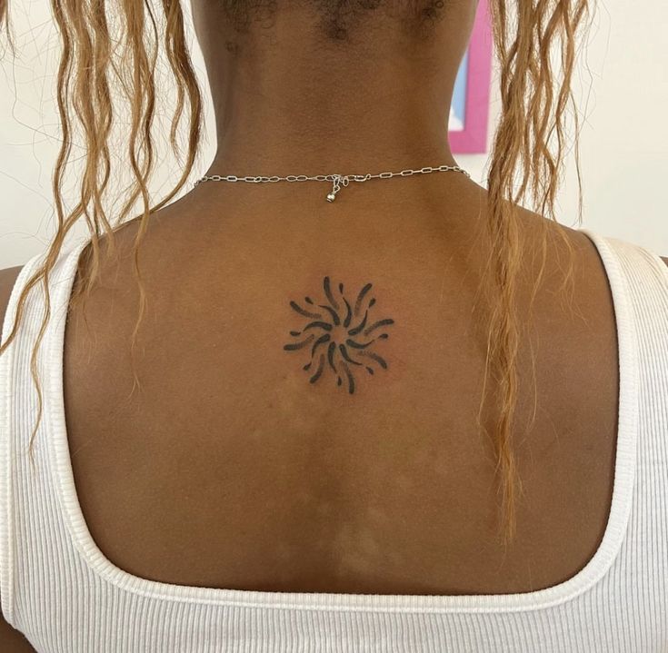 a woman with a tattoo on her back neck