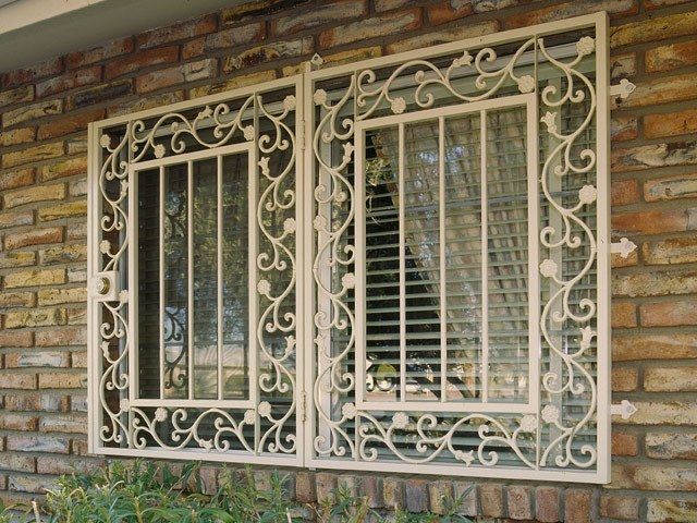 an iron window on the side of a brick building