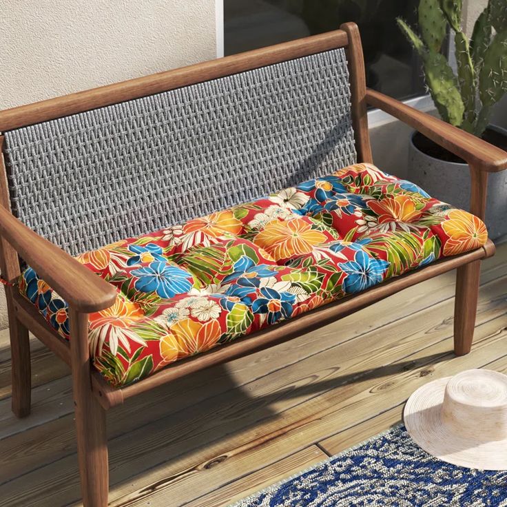 a wooden bench sitting on top of a wooden floor next to a potted plant