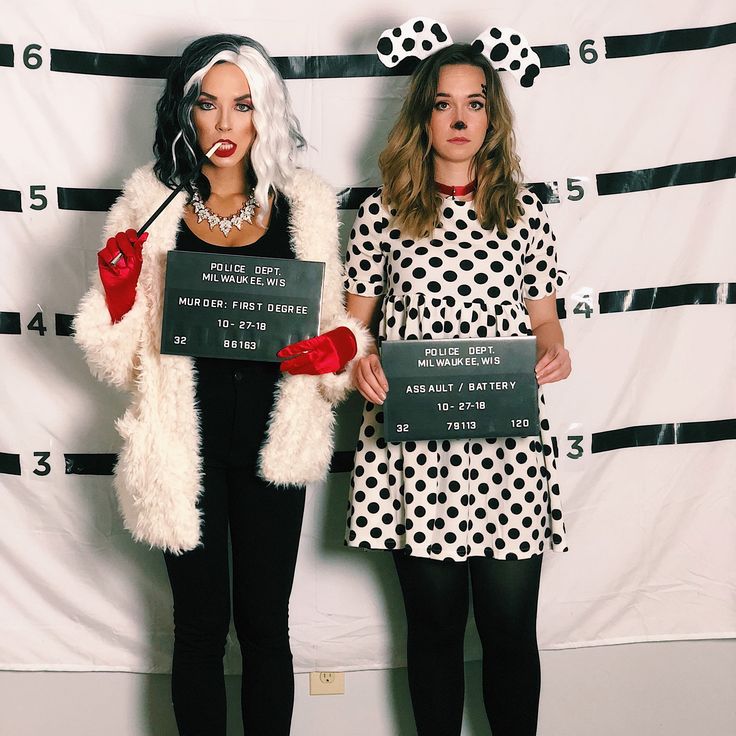 two women dressed in costumes standing next to each other holding signs that read, i love you