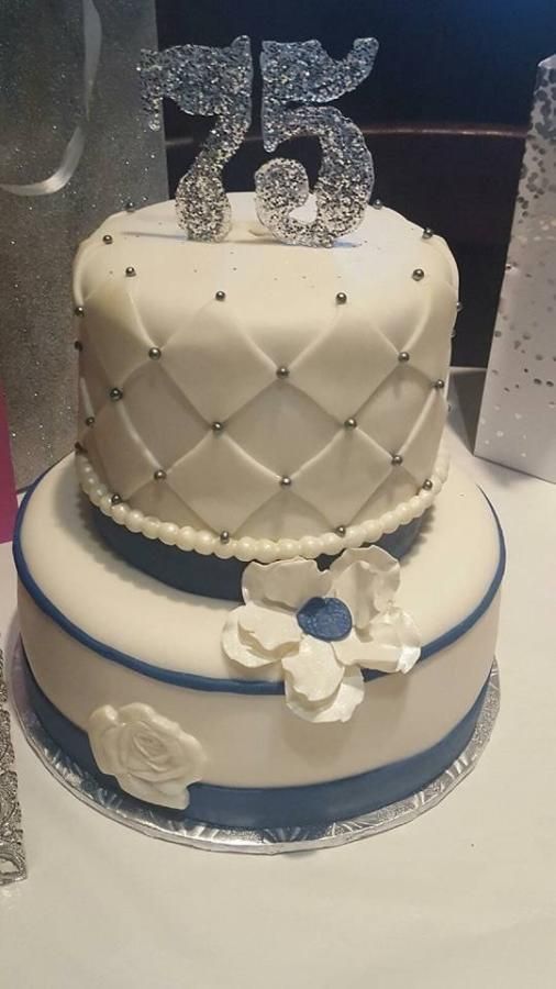 a three tiered cake with white and blue decorations