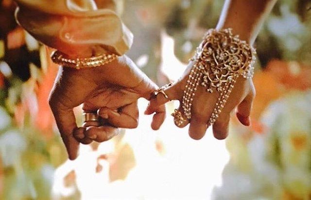 two people holding hands while standing next to each other with bracelets on their wrists