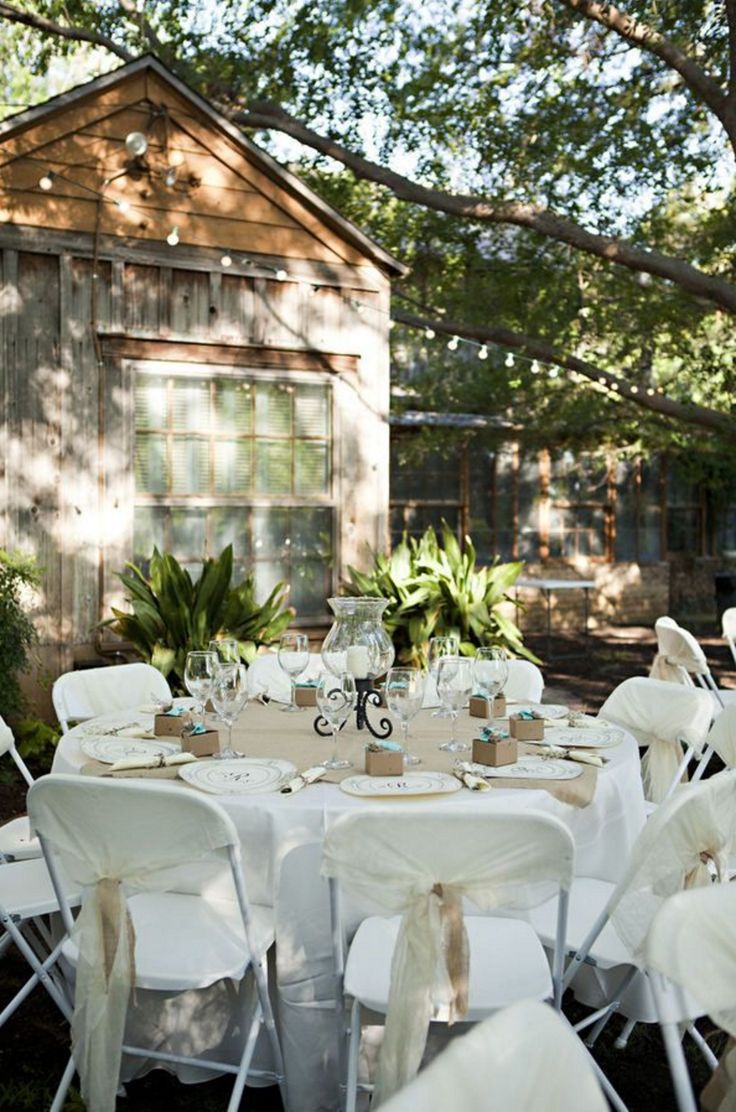 an outdoor wedding venue with white chairs and tables