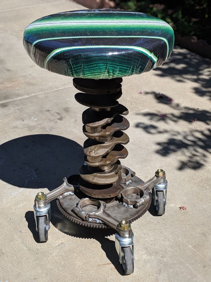 a green and black object sitting on top of a sidewalk