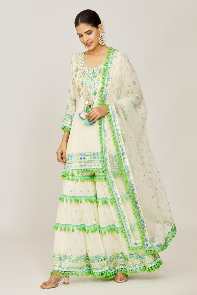 Ivory straight kurta with mirror, sequin, pompom and tassel details. Paired with a layered embroidered sharara and net embroidered dupatta.
Components: 3
Pattern: Embroidered
Type Of Work: Hand and machine embroidery
Neckline: Round
Sleeve Type: Three-quarter
Fabric: Kurta: Viscose, Sharara: Cotton Satin, Dupatta: Net
Color: Ivory
Other Details: 
Sequin and mirror embroidery
Sharara closure: Drawstring
Occasion: Mehendi and Haldi - Aza Fashions Layered Sharara, Satin Dupatta, Gopi Vaid, Embroidered Sharara, Embroidery Neckline, Mirror Embroidery, Embroidered Dupatta, Straight Kurta, Sharara Set