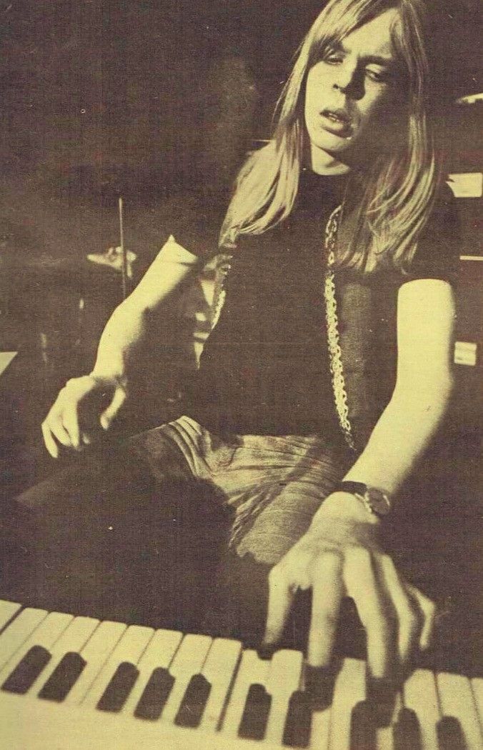 a woman sitting at a keyboard with her hand on the keys