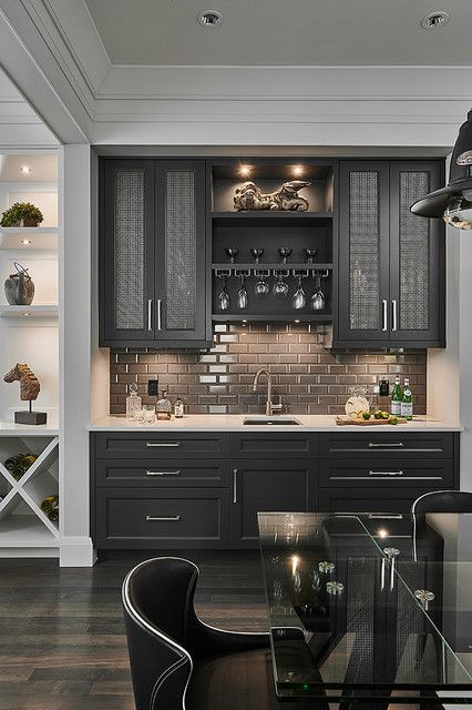 a kitchen with black cabinets and glass table