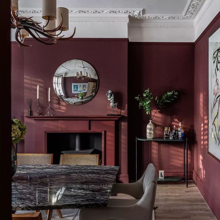 a dining room with red walls and wooden floors