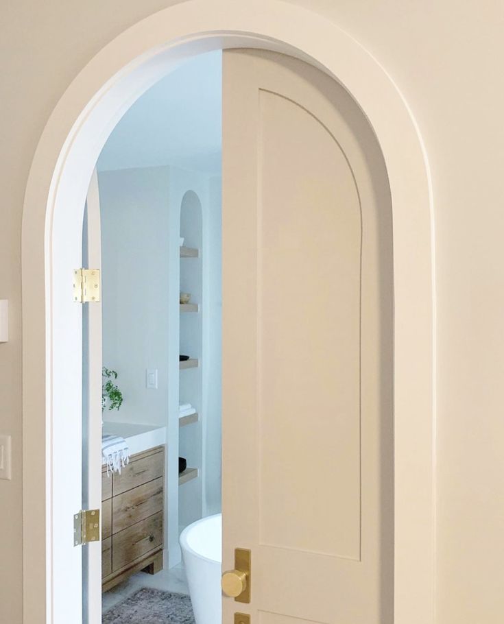 an open door leading to a bathroom with a tub