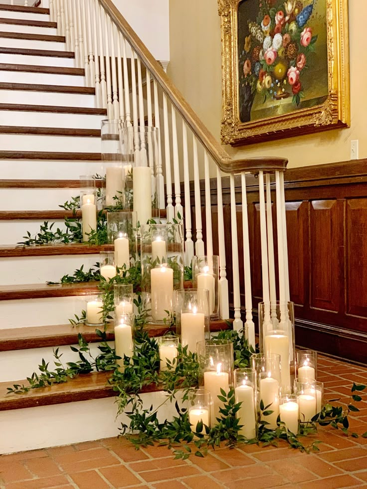 candles and greenery are arranged on the stairs