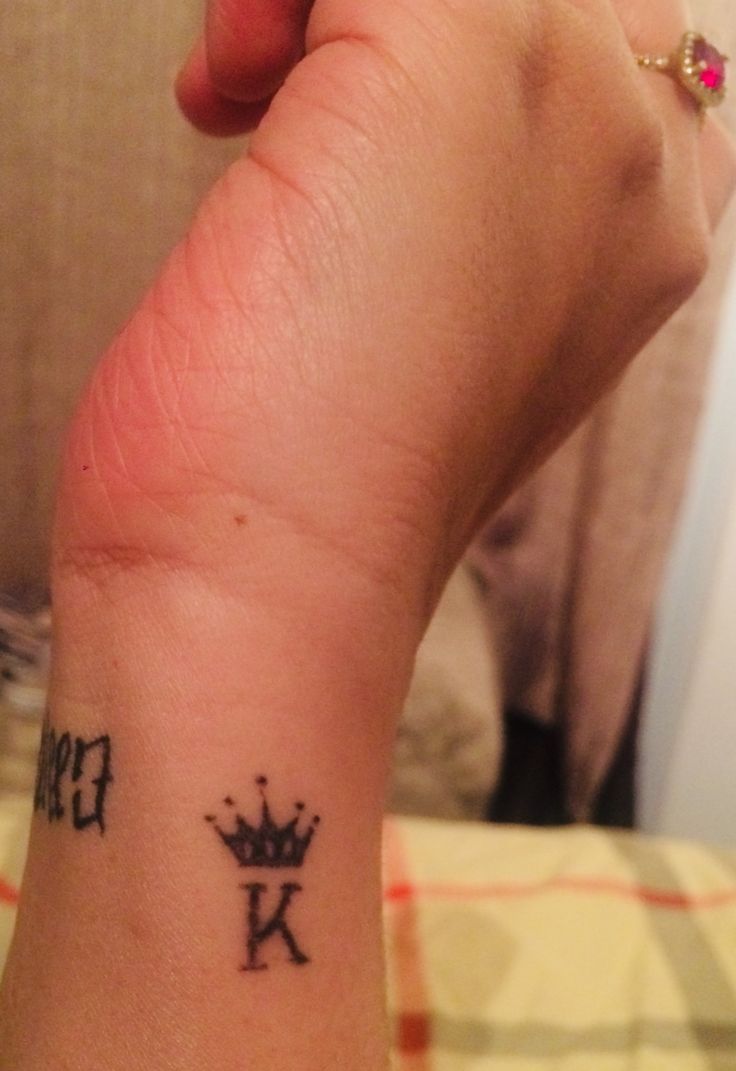 a person with a crown tattoo on their wrist