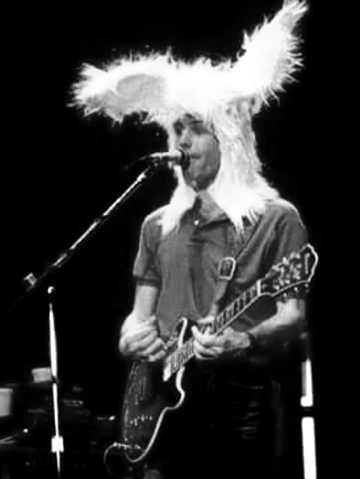 a man with long white hair is playing guitar