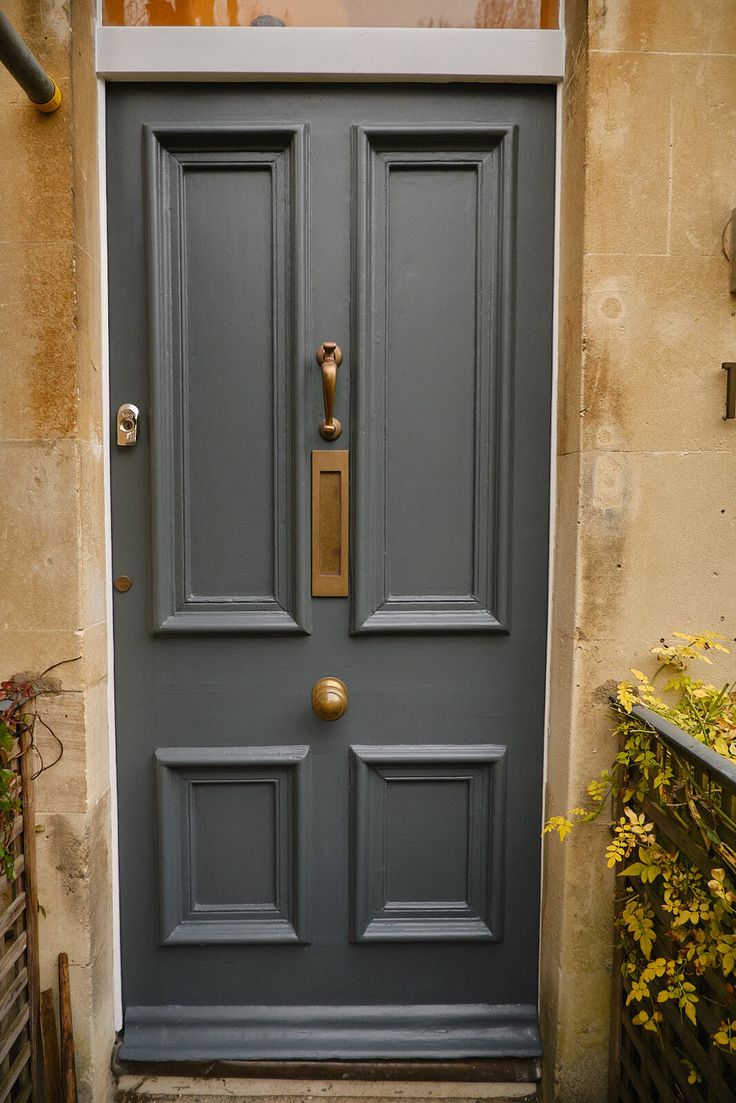 the front door is painted blue and has a gold handle on it's side