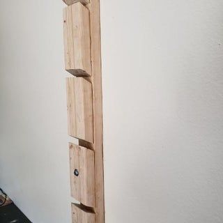 an unfinished piece of wood is hanging on the wall