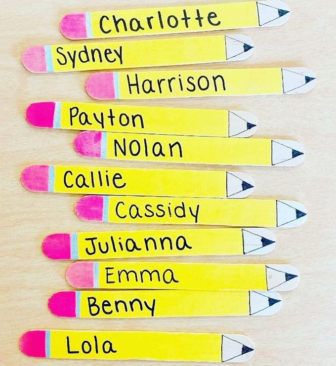 pencils with names written on them are lined up in the shape of toothpicks