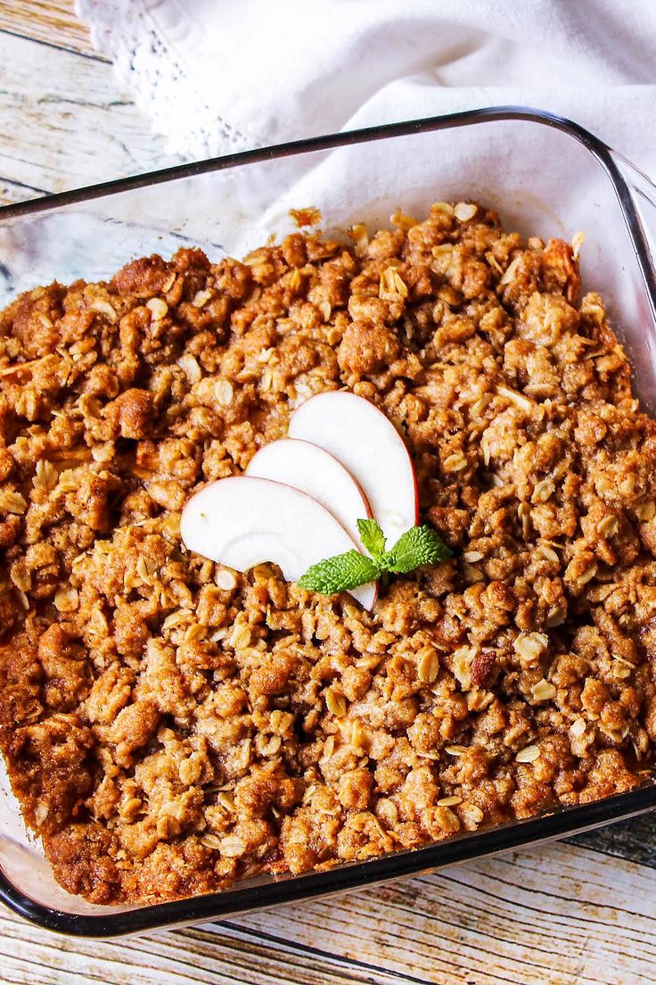 a casserole dish filled with granola and sliced apples