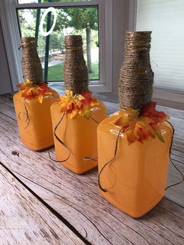 three orange pumpkins with twine and burlocks tied to them sitting on a wooden table