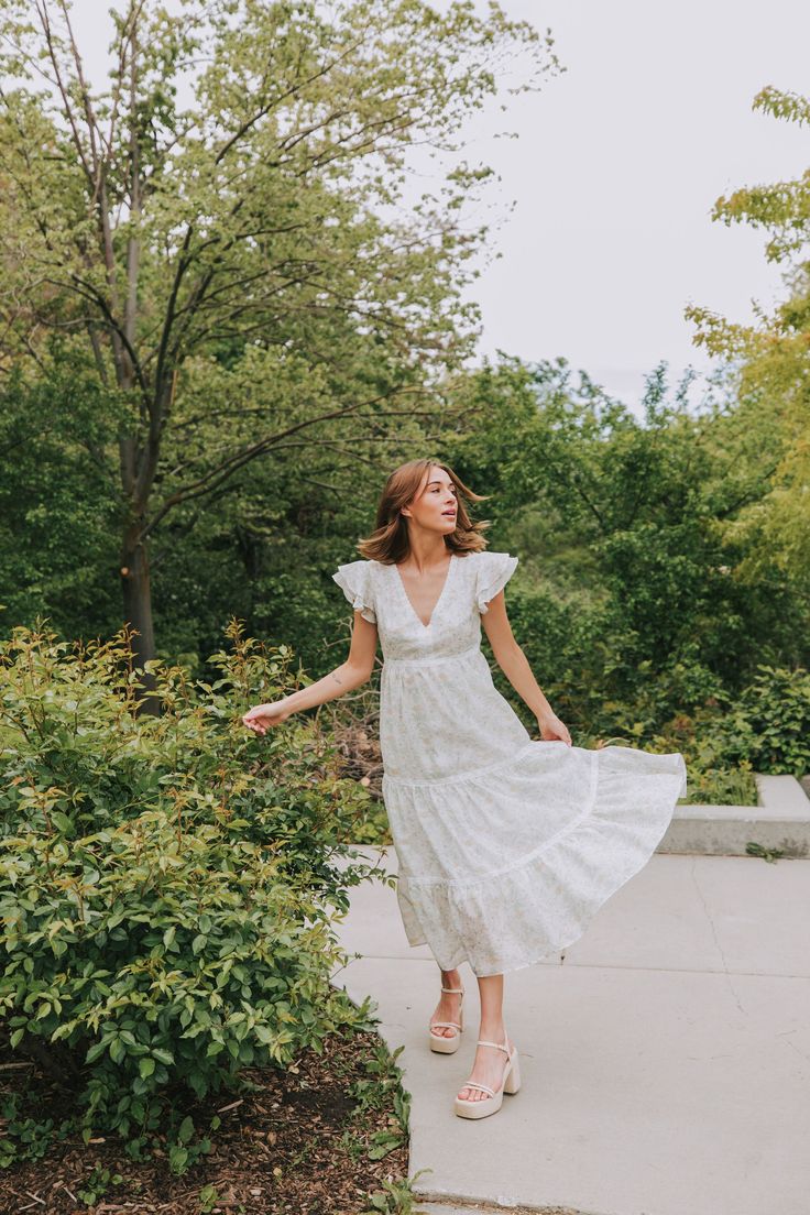 Get ready to turn heads in our EXCLUSIVE Move With Me Dress! With its unique floral pattern featuring yellow, sage, and lavender details, this midi dress is perfect for any occasion. The tiered design adds playful movement, while the double ruffle flutter sleeves and V-neck add a touch of femininity. The lace overlay on the neckline, chest, waistline, and hemline adds a flirty touch, while the elastic waist and side zipper provide a comfortable and flattering fit. Don't miss out on this one-of-a White Midi-length Tiered Dress For Garden Party, White Midi Length Tiered Dress For Garden Party, White Midi Tiered Dress For Garden Party, Spring Tiered Midi Dress For Garden Party, Floral Print Midi Length Tiered Dress For Spring, Tiered Midi Dress For Spring Garden Party, Spring Day Out Tiered Midi Dress, Spring Midi-length Tiered Dress For Day Out, Spring Midi Length Tiered Dress For Day Out