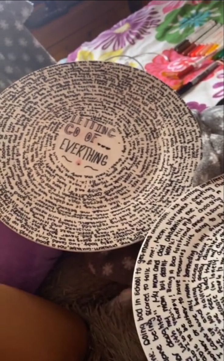 two plates with words written on them sitting next to each other in front of a table