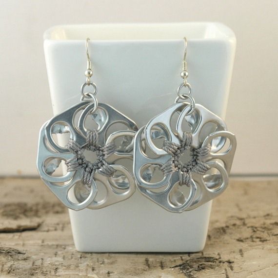 a pair of silver earrings sitting on top of a table