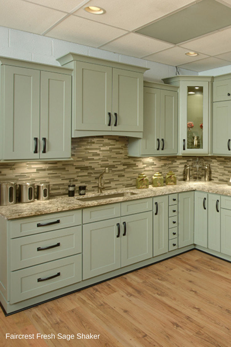 an empty kitchen with light green cabinets and wood flooring is pictured in this image