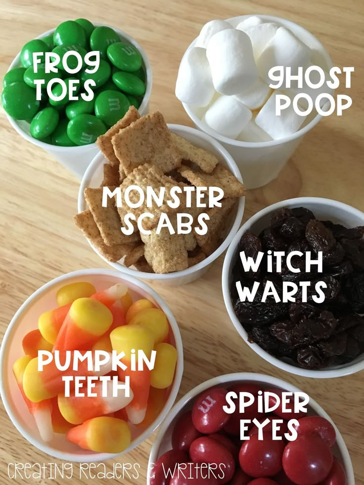 four bowls filled with different types of candy and marshmallows on top of a wooden table