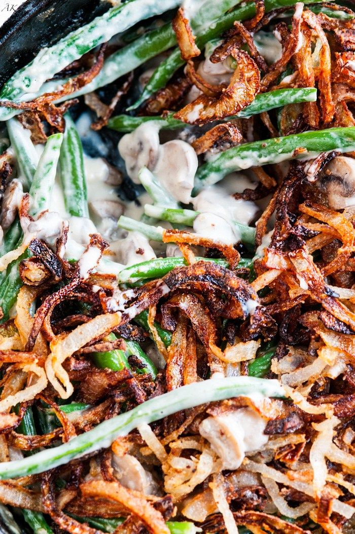 green beans, onions and mushrooms are in a skillet with white sauce on top