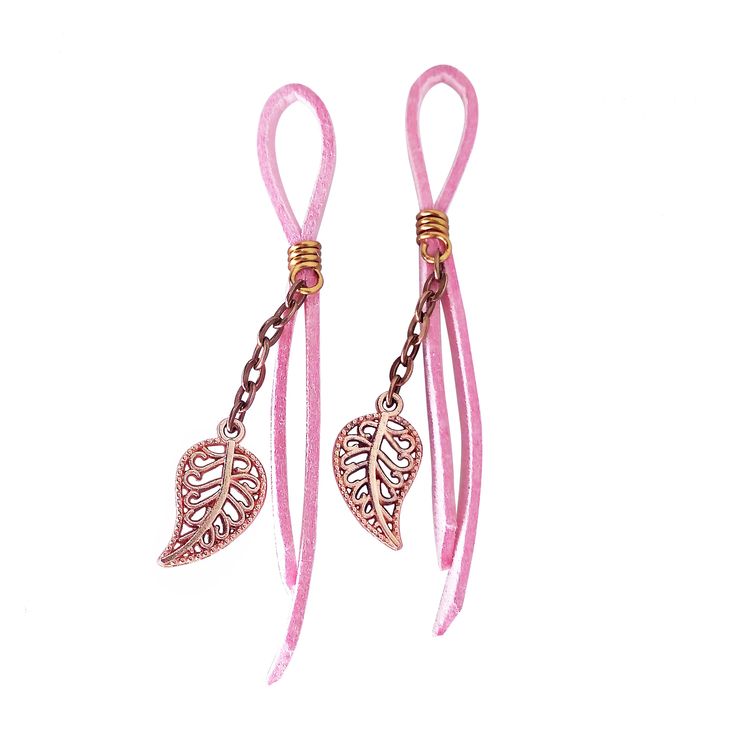 pair of pink cord earrings with heart shaped charms on the end and chain attached to each ear