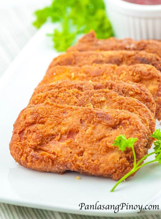 three fried chicken patties on a white plate with parsley and ketchup