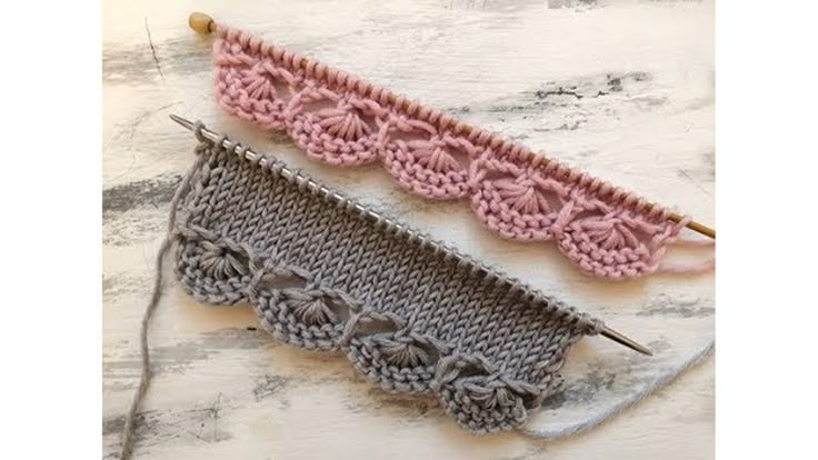 two crocheted knitting needles sitting next to each other on top of a table