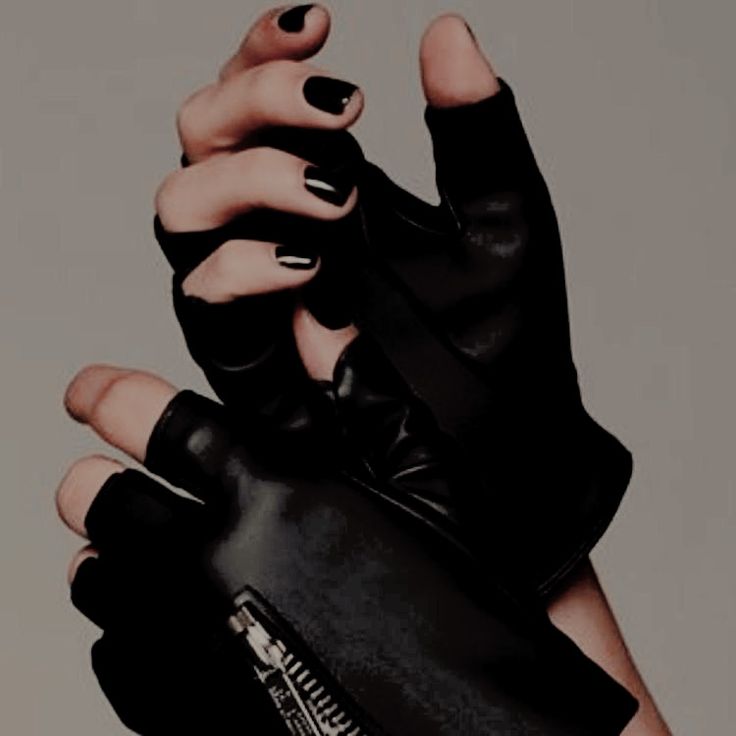 a woman's hands with black nail polish and gloves