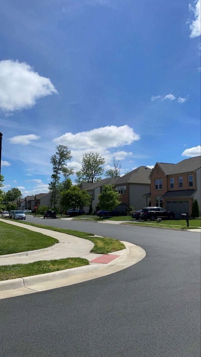 an empty street with houses in the background