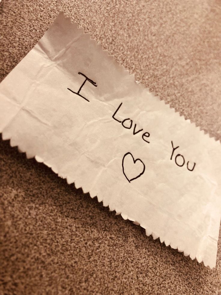 a piece of paper with the words i love you written on it sitting on carpet