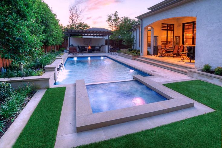 an outdoor swimming pool surrounded by lush green grass